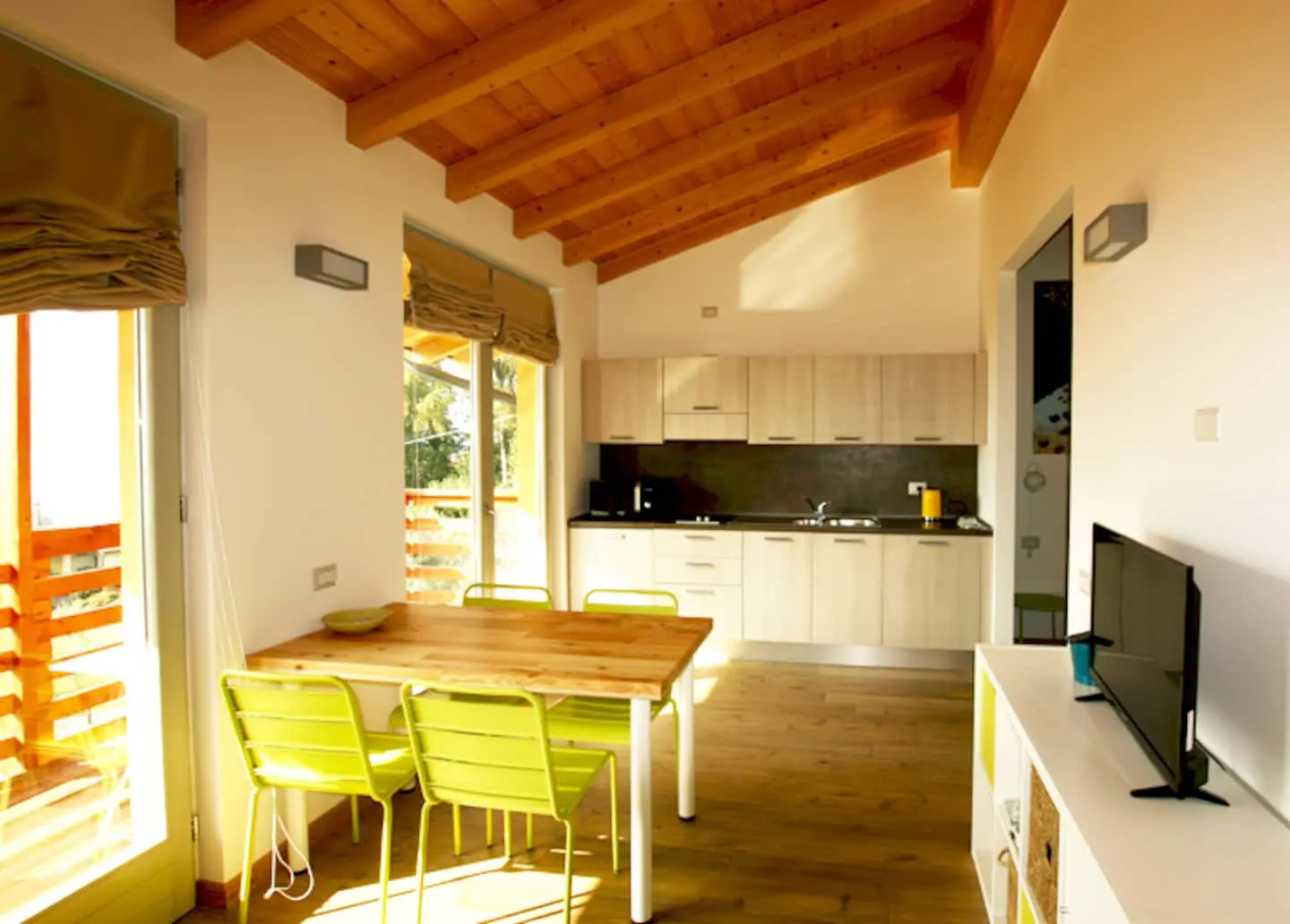 Open space con travi in legno e cucina